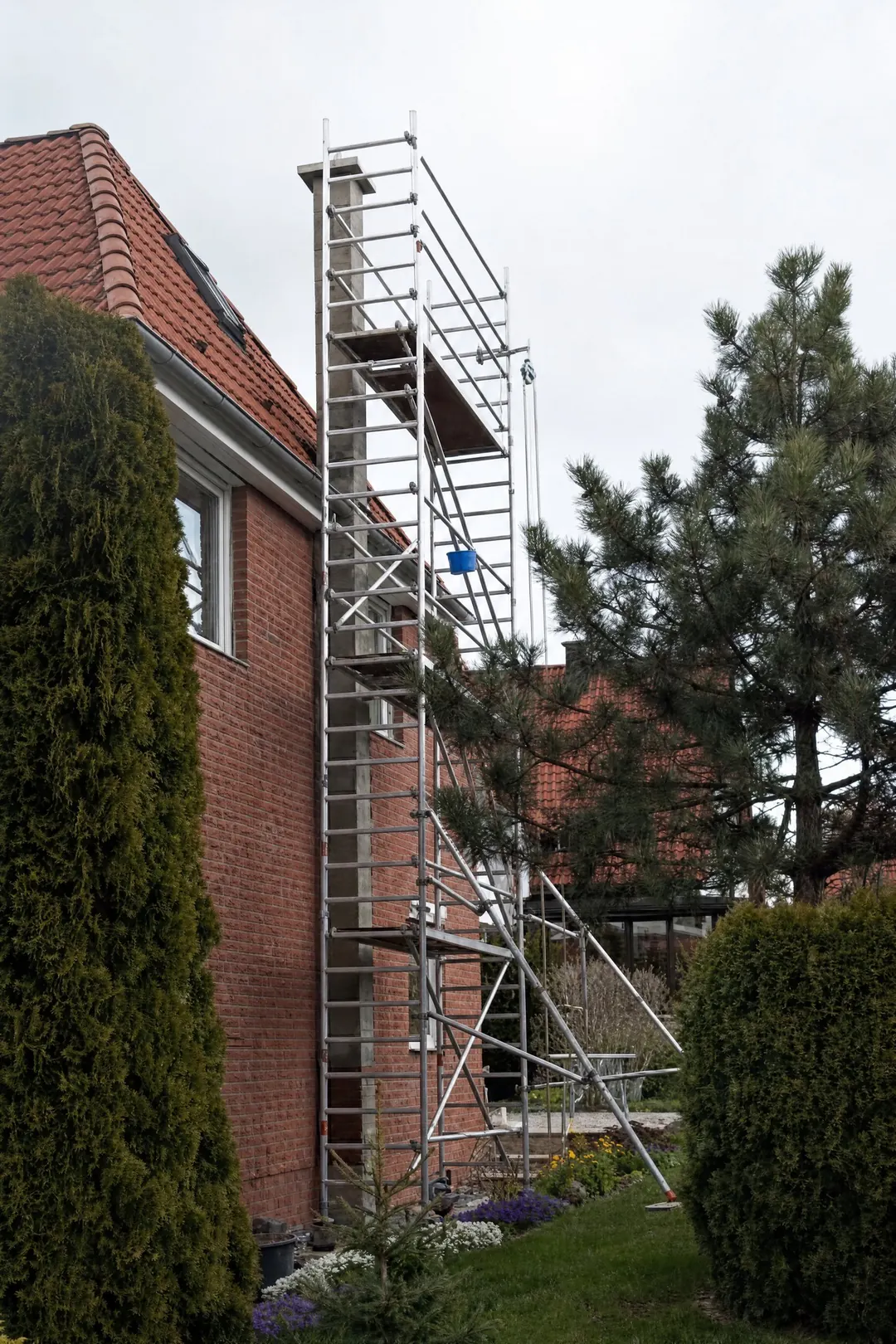 Montage eines Schornsteins an einer Hausfassade mit Fahrgerüst